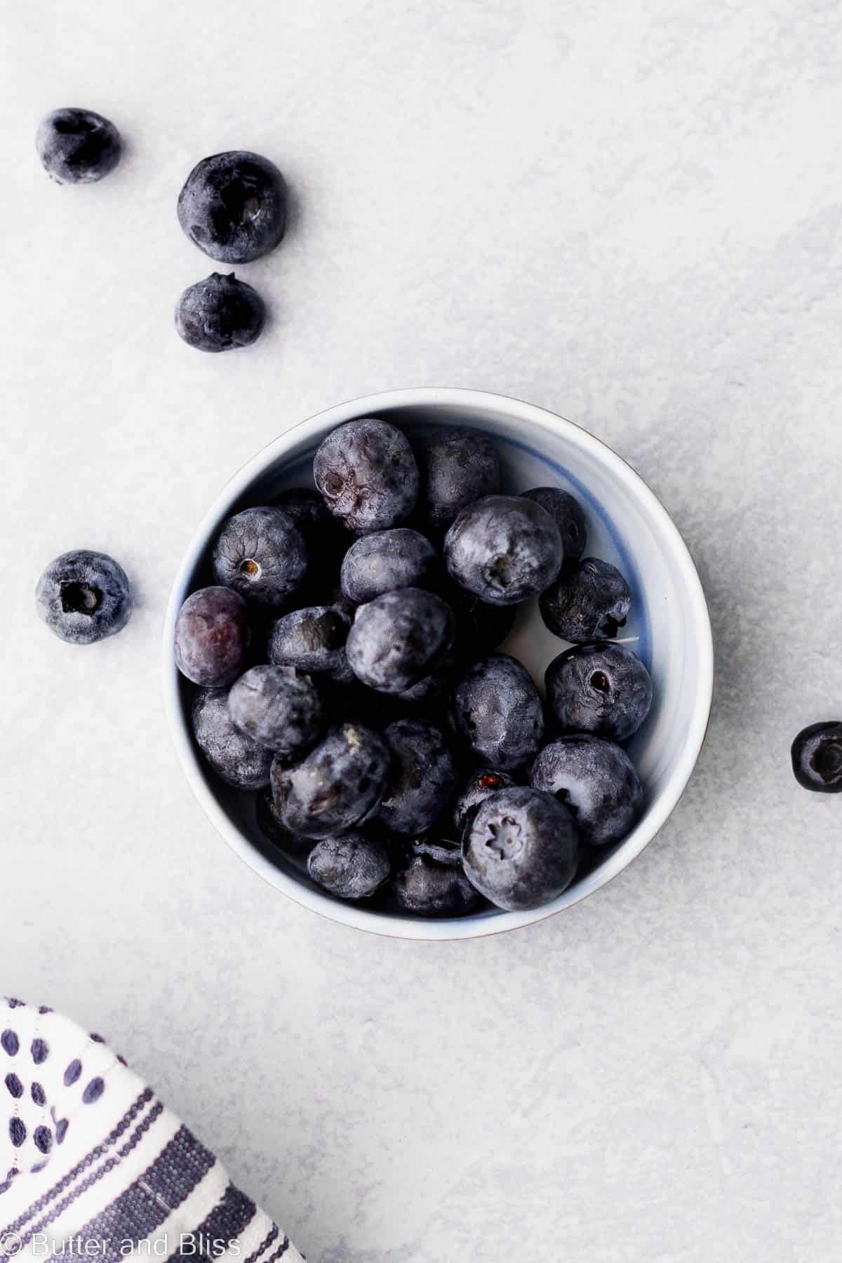 Small blue bowl filled with fresh blueberries.