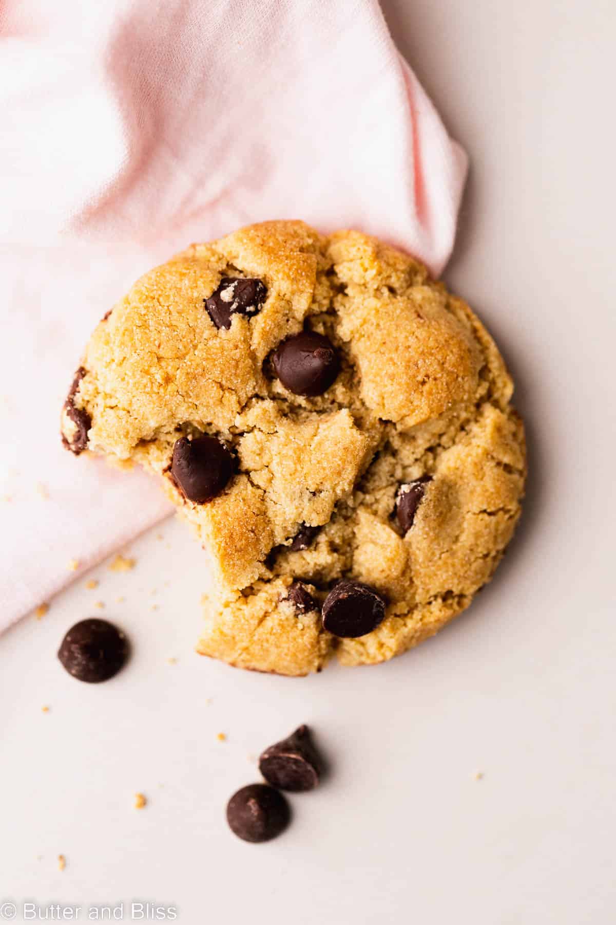 Single cookie with a bite on a table.