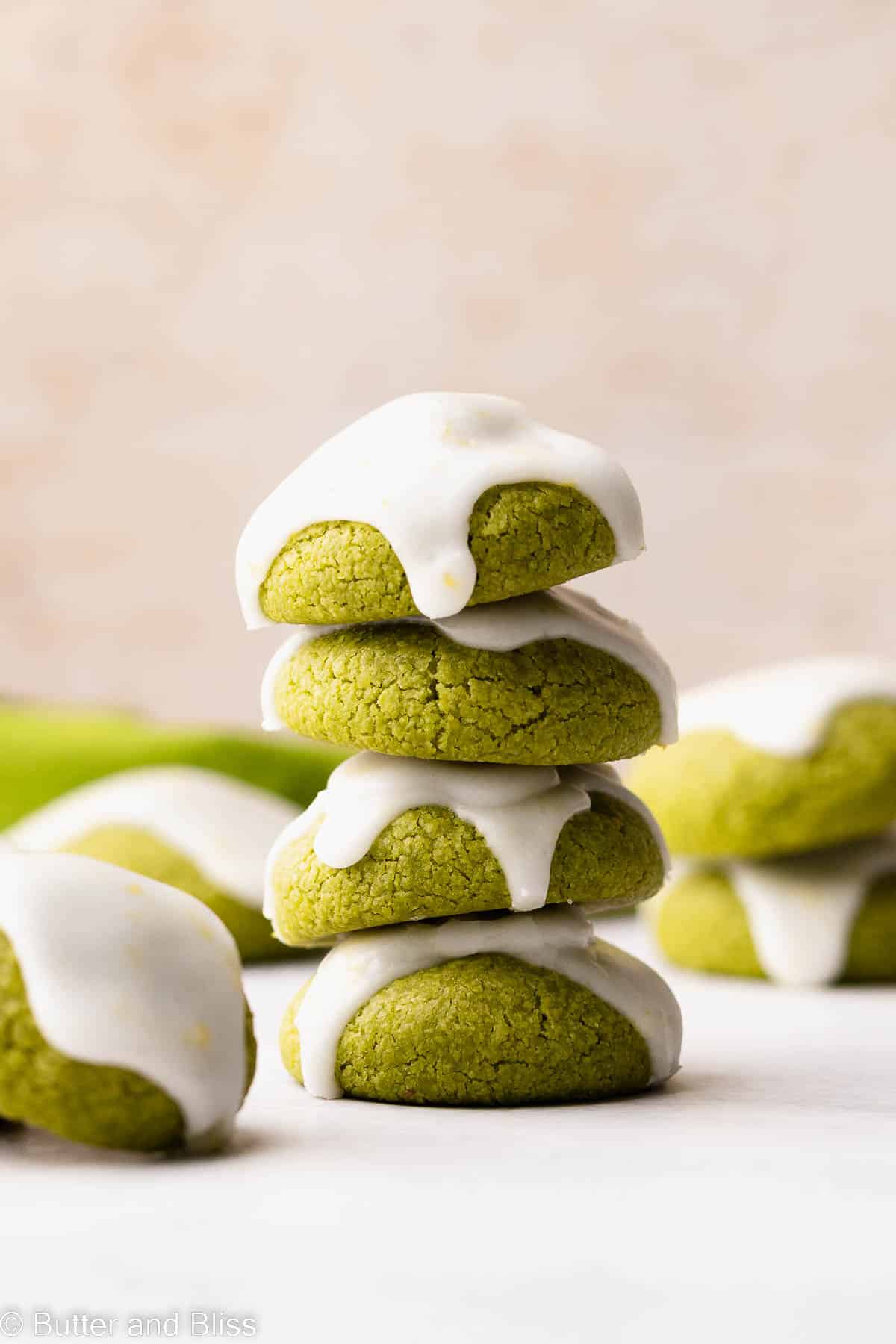 Short stack of iced matcha green tea gluten free cookies on a table.
