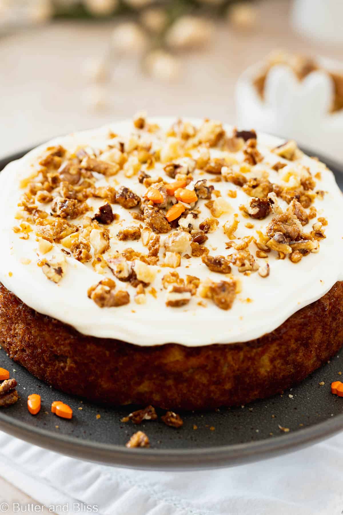 Close up of mini carrot cake with frosting and walnut topping.