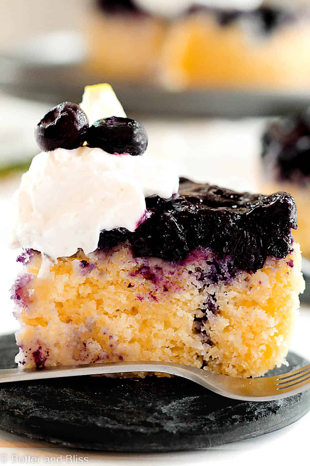A fresh slice of blueberry upside down cake on a mini cake plate.