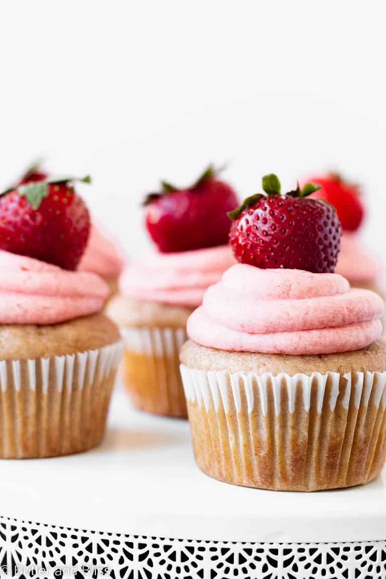 A cake platter full of strawberry cupcakes.