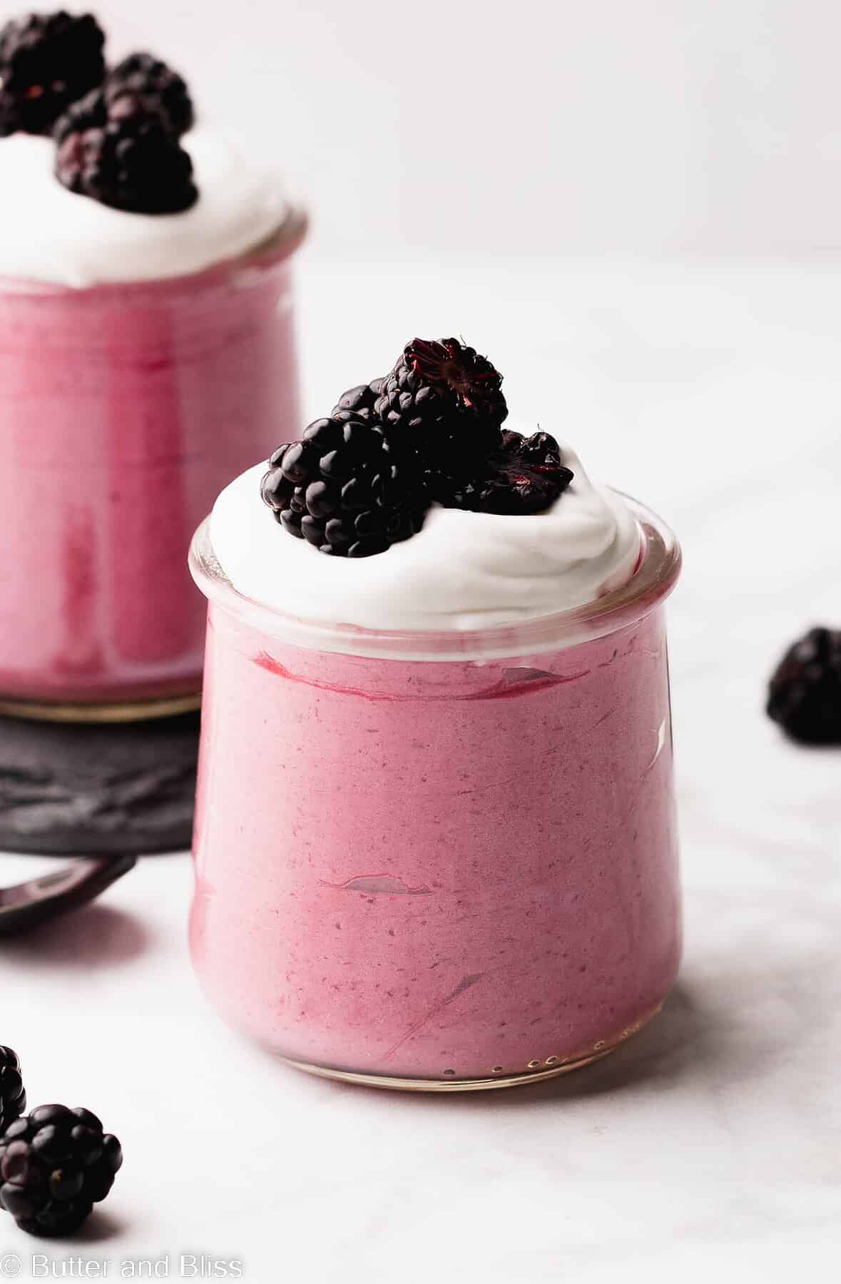 Super creamy summer fruit dessert in a serving glass set on a table.