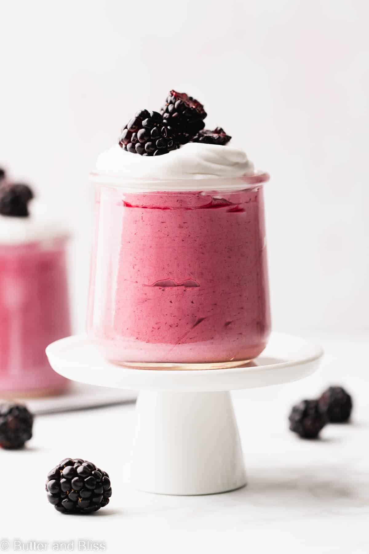The prettiest blackberry mousse topped with whipped cream in a mini serving glass.
