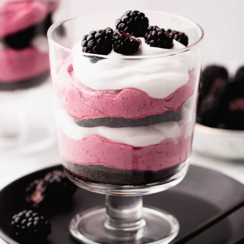 A pretty blackberry trifle parfait in a small trifle glass.