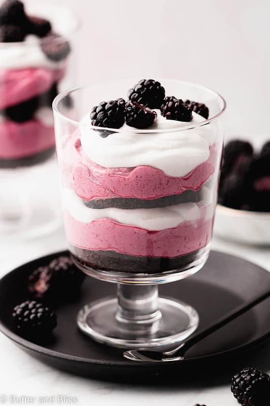 A pretty blackberry trifle parfait in a small trifle glass.