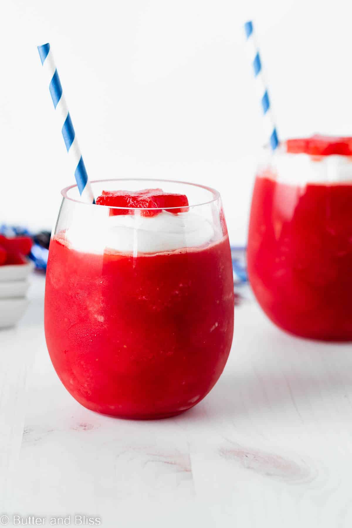 Fruity summer frozen drinks with creamy topping on a picnic table.