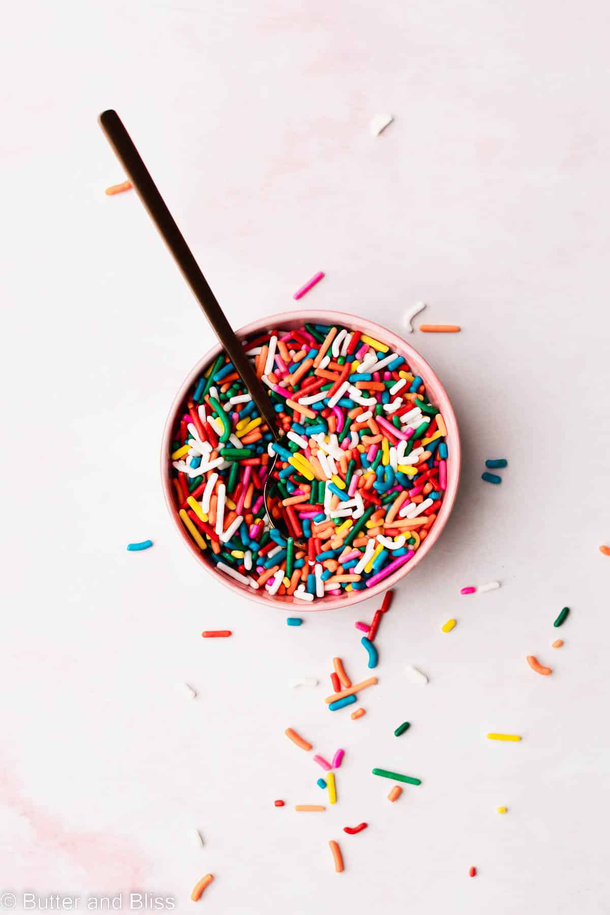 A pretty picture of a small bowl of sprinkles.