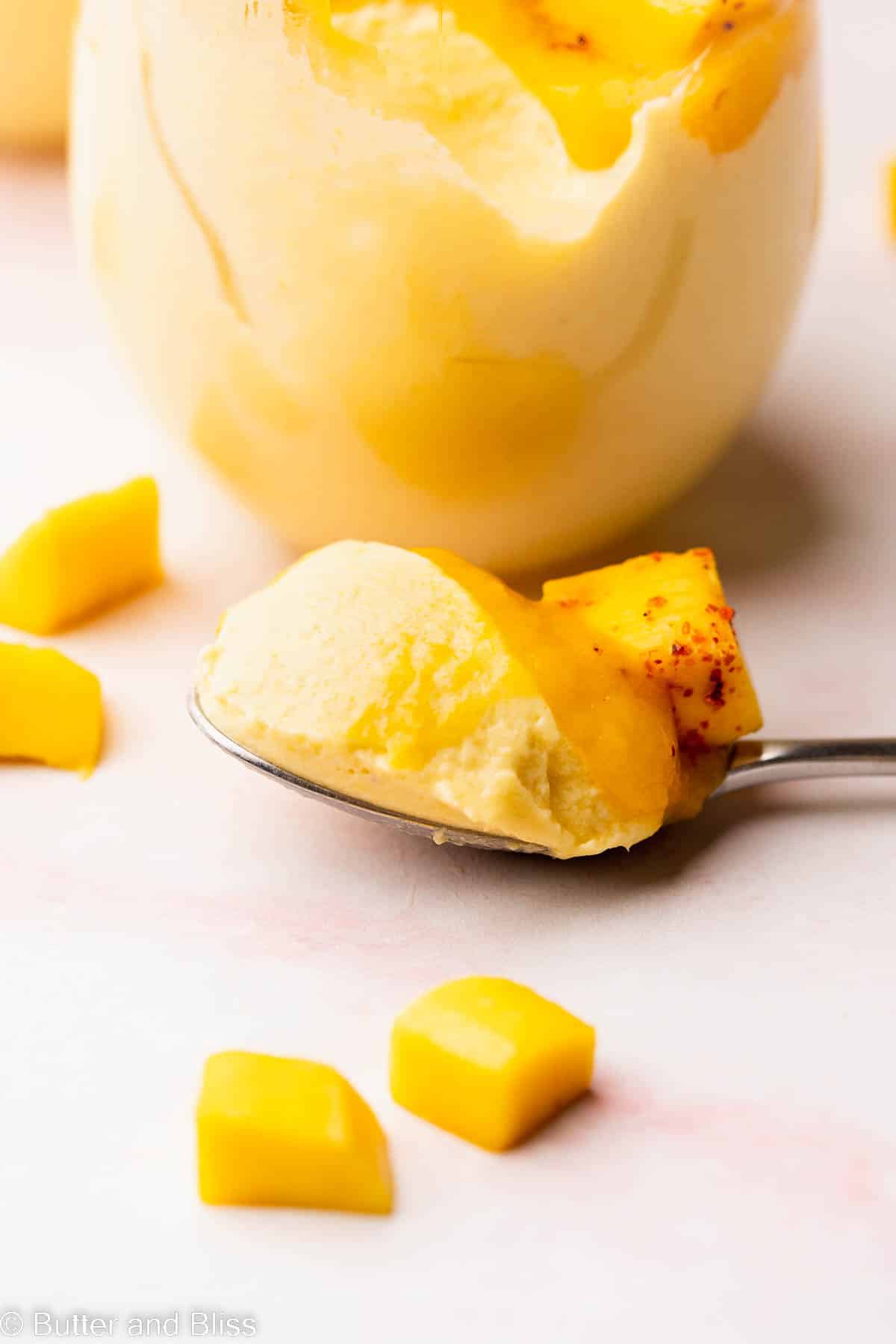 Bite shot of a spoonful of creamy mango mousse.