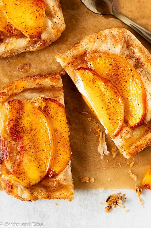 Single mini peach and cream cheese tart sliced in half and drizzled with honey.