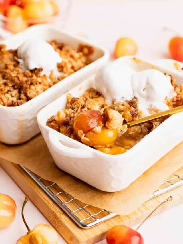Pretty dishes full of gooey gluten free cherry crisp topped with ice cream.