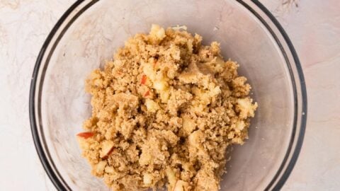 Streusel studded with small apple pieces in a mixing bowl.