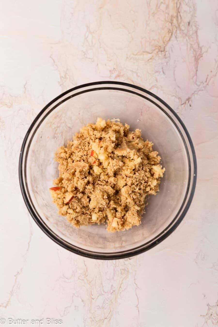 Streusel studded with small apple pieces in a mixing bowl.