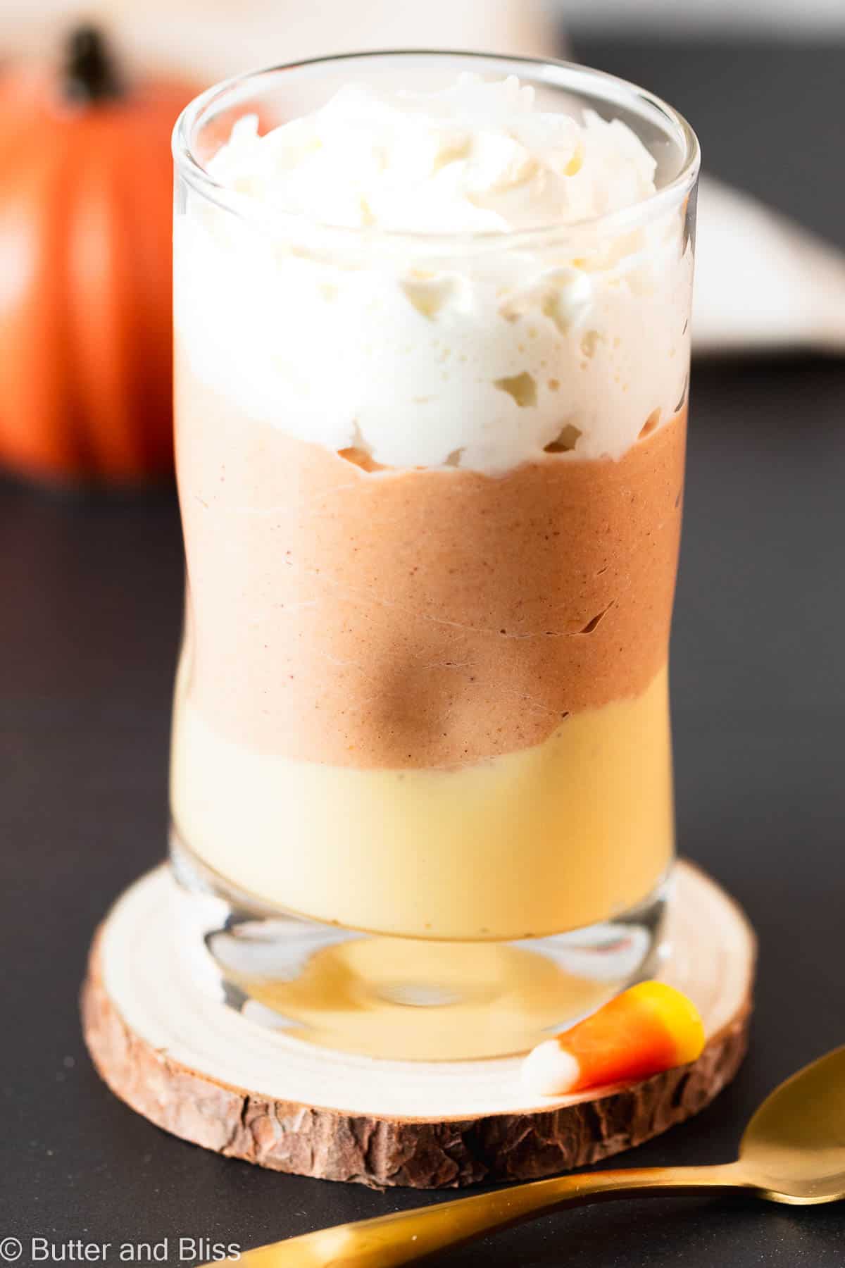 Pretty layered Halloween layered dessert in a parfait in a glass on a table.