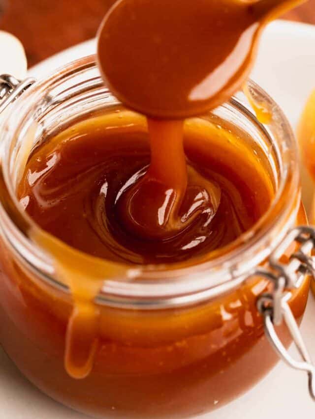 Apple cider caramel sauce ribbons streaming into a cute glass jar.