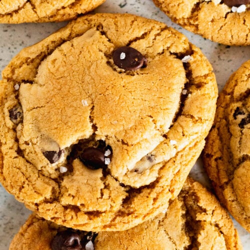 Close up of a pile of caramel chocolate chip cookies finished with flaky salt.