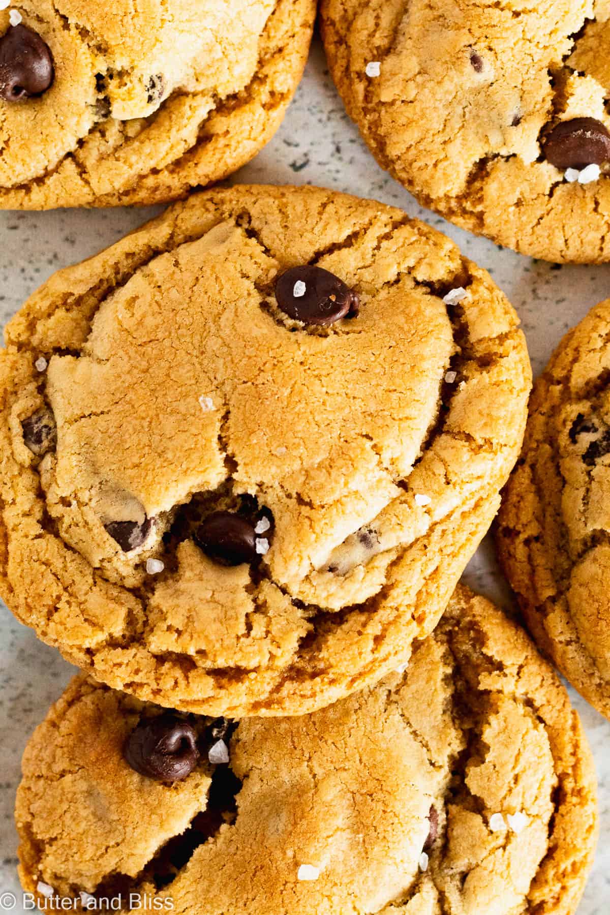 Close up of a pile of caramel chocolate chip cookies finished with flaky salt.