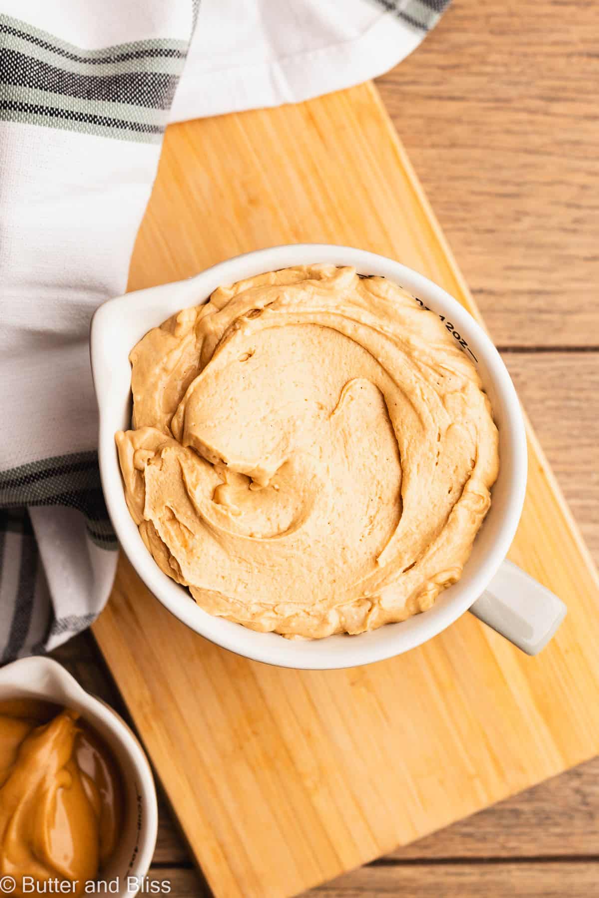 Creamy peanut butter fluff frosting in a pretty white bowl.