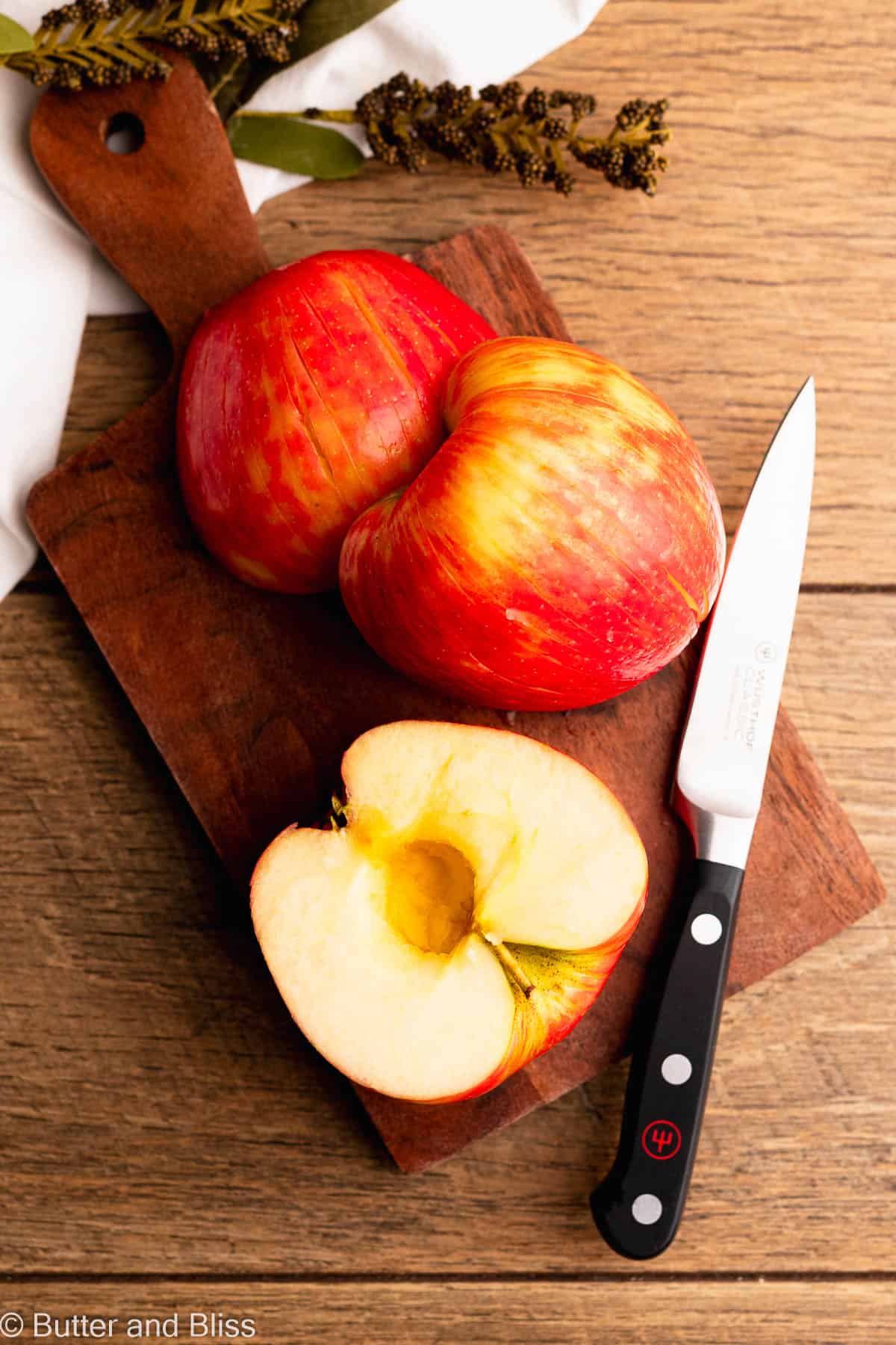 Sliced and cored Honeycrisp apple on a wood cutting board.