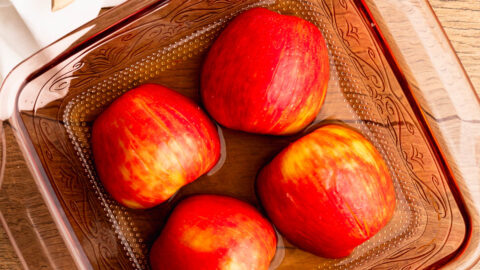 Sliced apples in a pretty baking dish waiting to be baked.