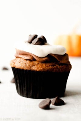 Single pumpkin cupcake topped with chocolate and cream cheese frosting.