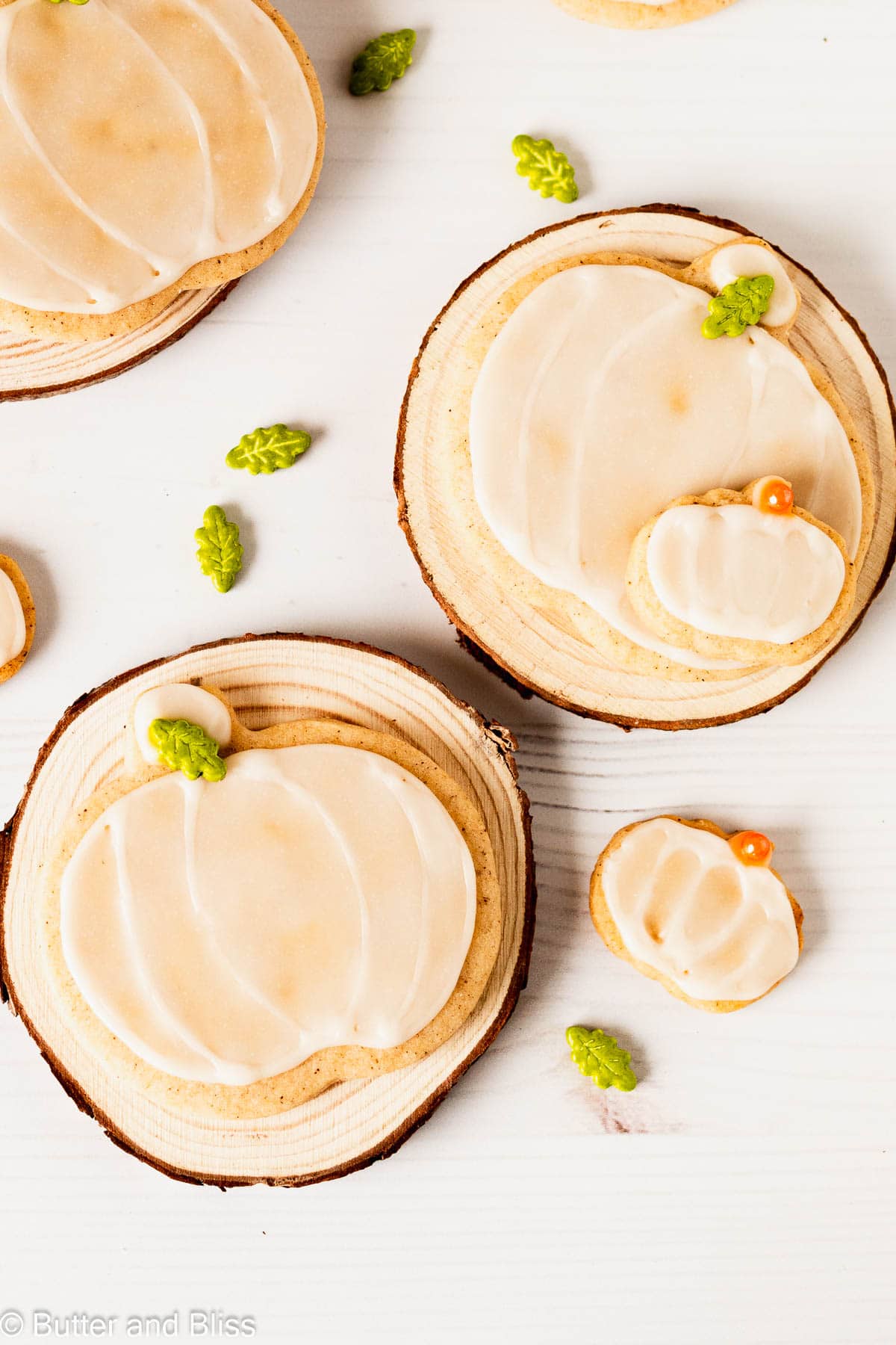 Iced fall cookies on small wooden plates on a table.