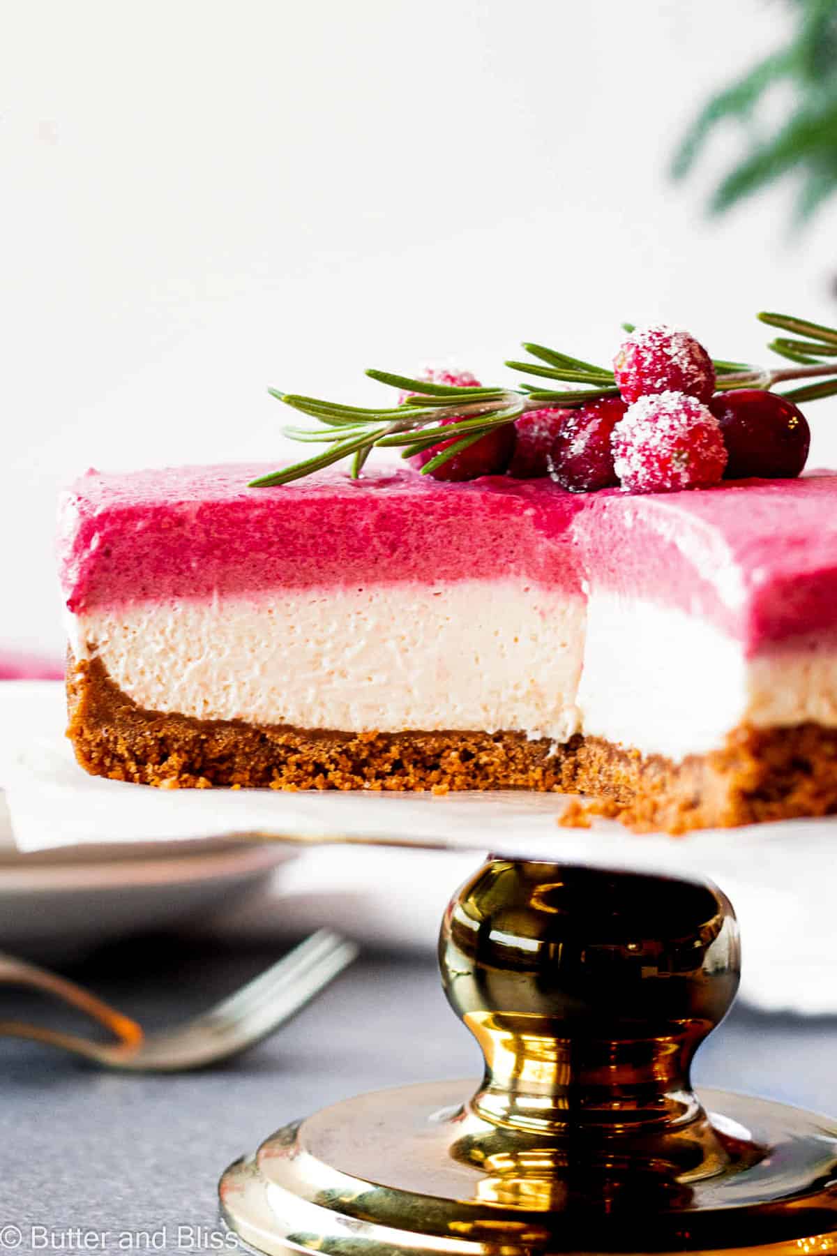 Super creamy interior of a cranberry cheesecake on a pretty cake stand.