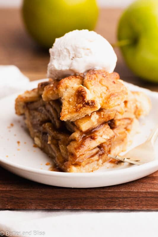 The perfect slice of gluten free apple pie a la mode on a pretty white plate.
