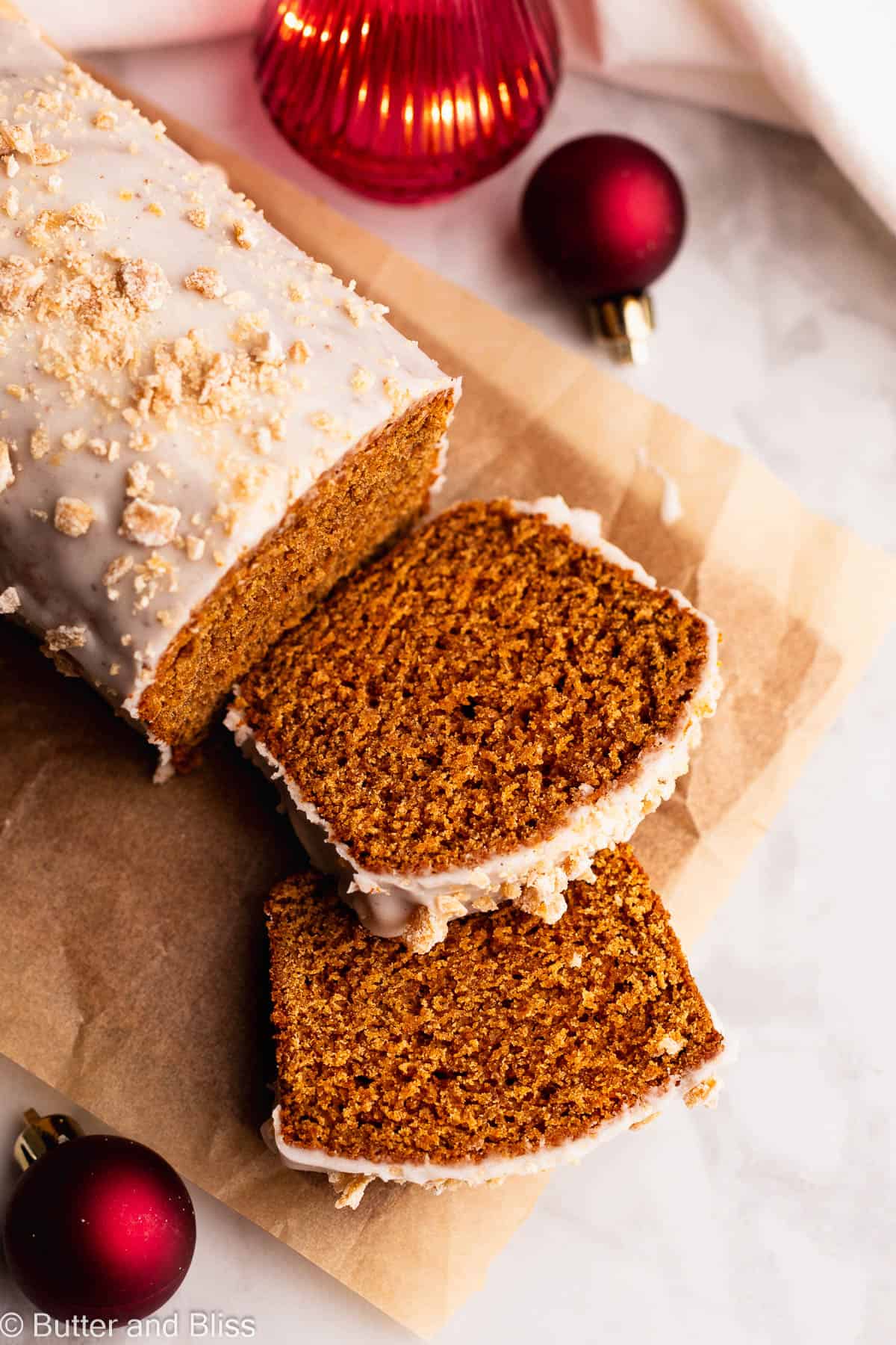 Two slices of gingerbread cut from the larger gluten free loaf arranged on parchment paper.