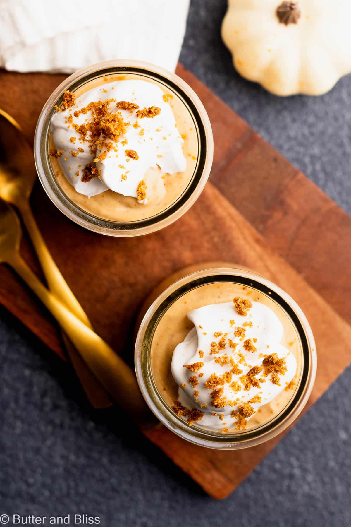 The top of a pretty Thanksgiving or fall desserts in small glasses topped with whipped cream.