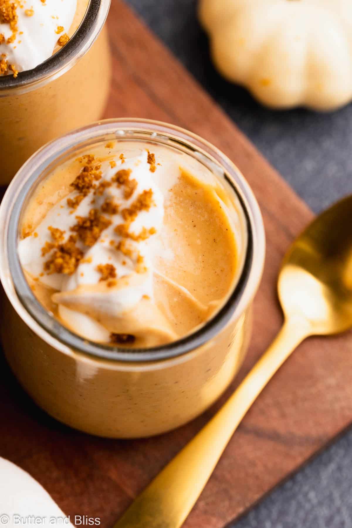 A look inside a super creamy pumpkin pudding dessert in a small glass jar.
