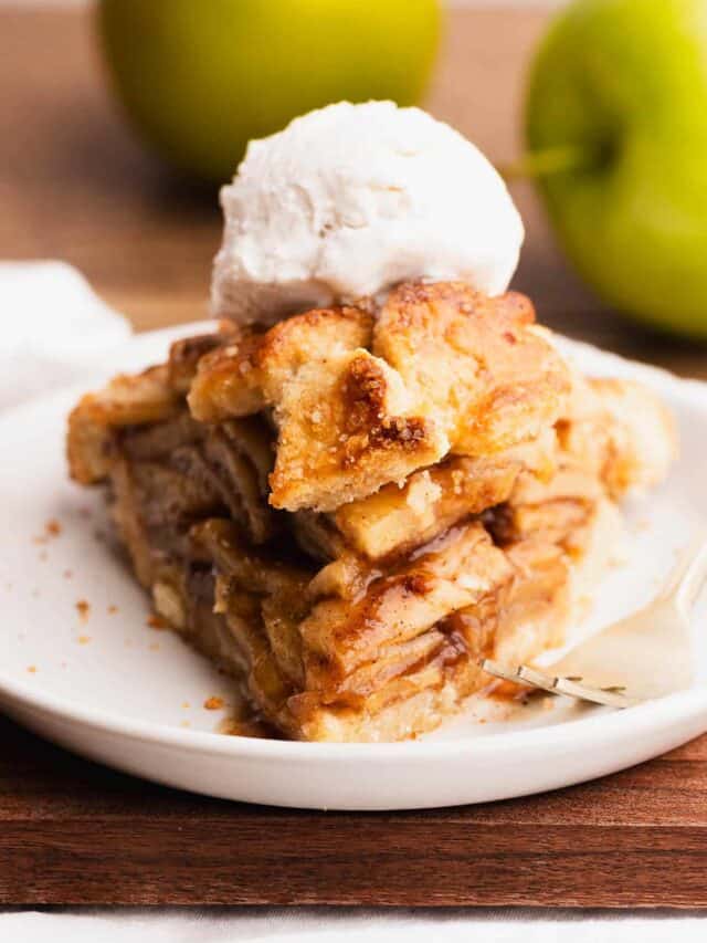 The perfect slice of gluten free apple pie a la mode on a pretty white plate.
