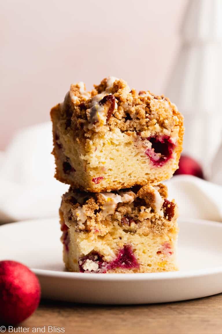 Two slices of cranberry breakfast gluten free cake stacked on a small white plate.