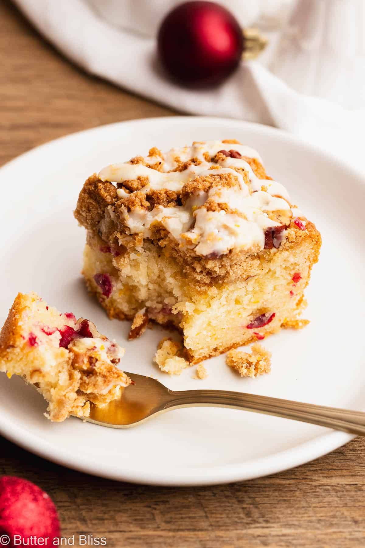 Slice of gluten free cranberry breakfast cake on a small plate with a fork.