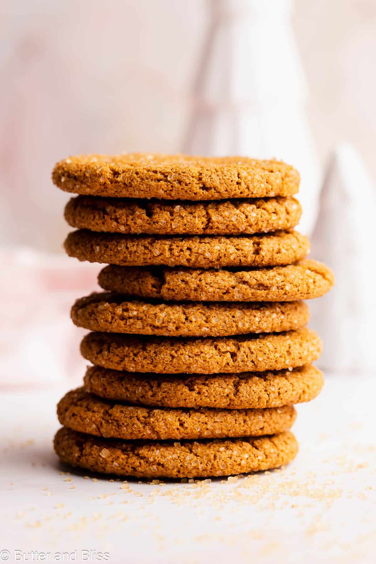 Pretty stack of Christmas molasses cookies on a white table.