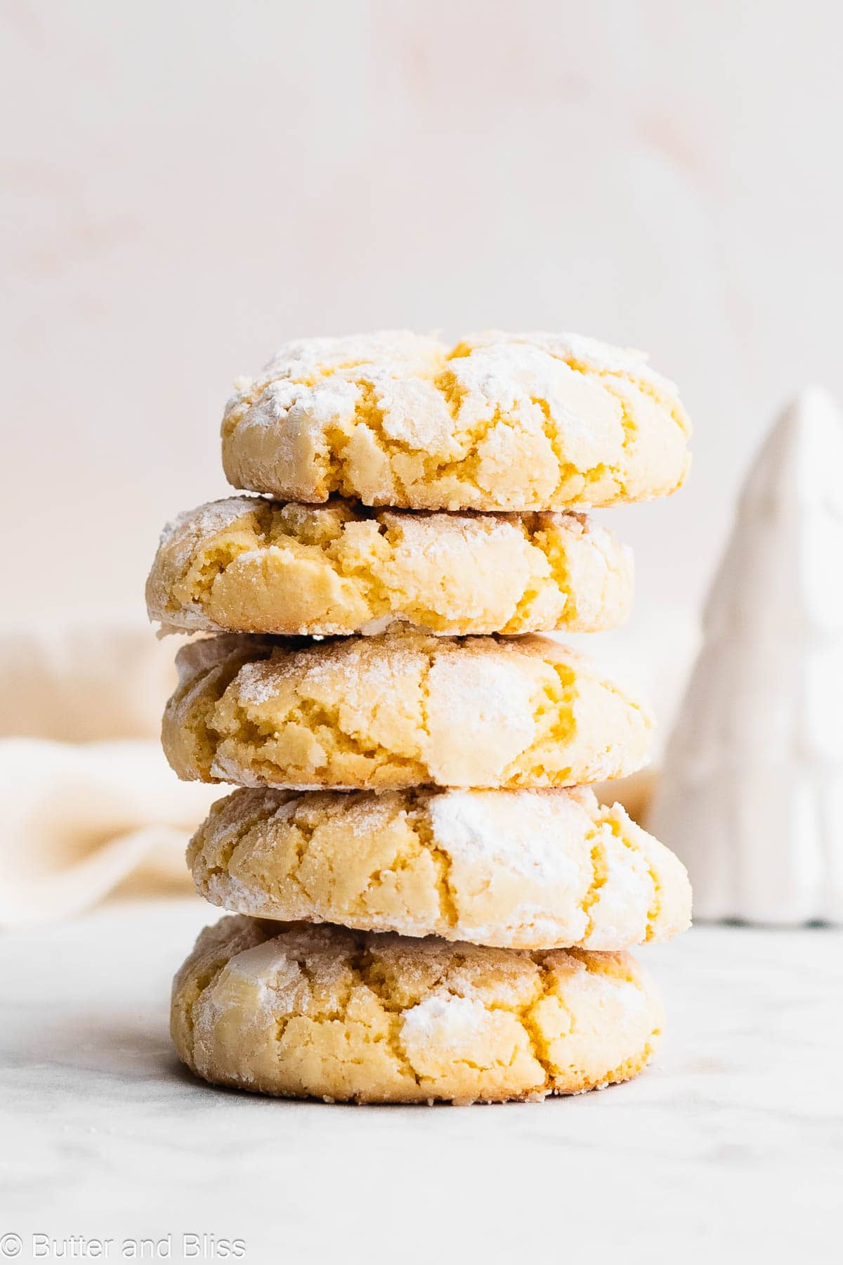 A perfect stack of lemon crinkle cookies on a table.