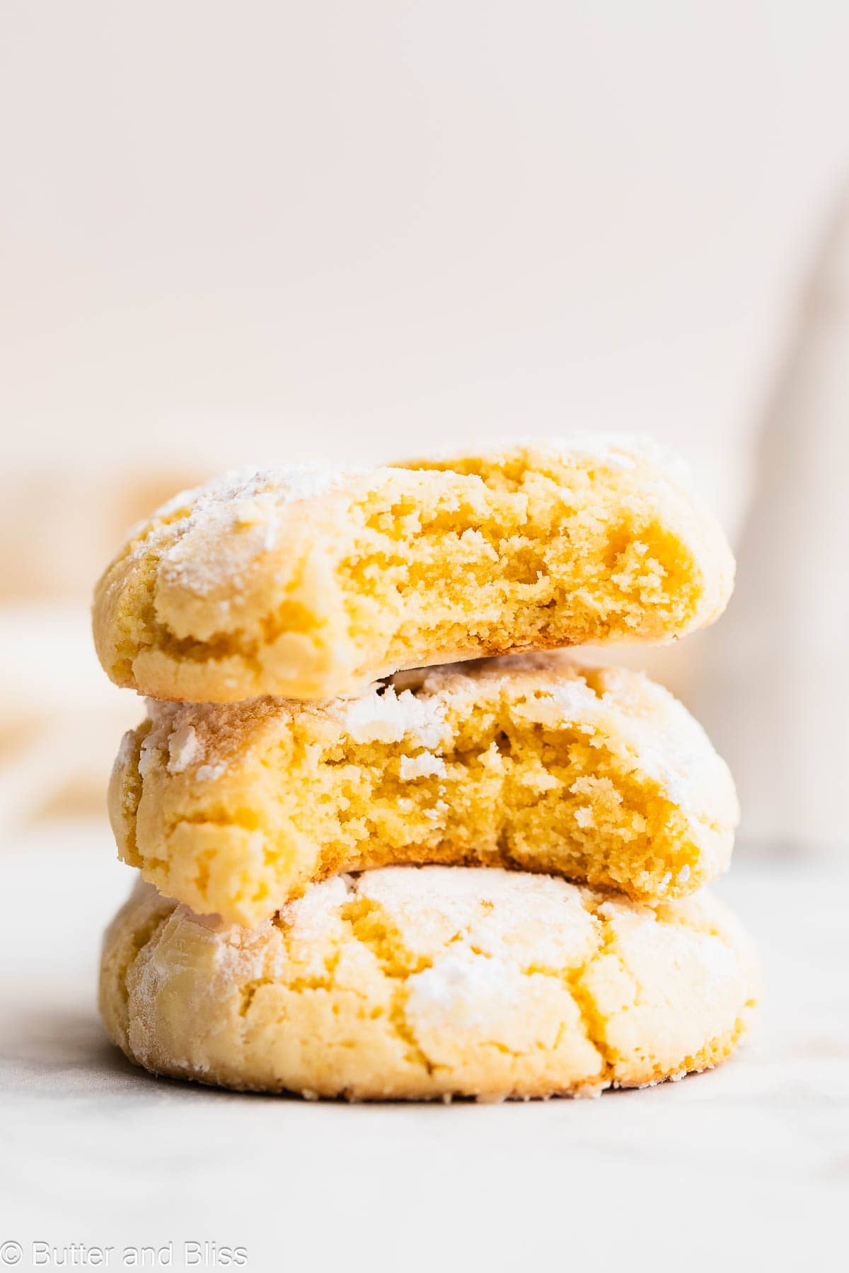 Soft and chewy inside of a gluten free lemon crinkle stacked on another cookie.