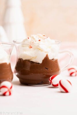 Pretty serving glass of hot cocoa pudding with marshmallow whipped cream.