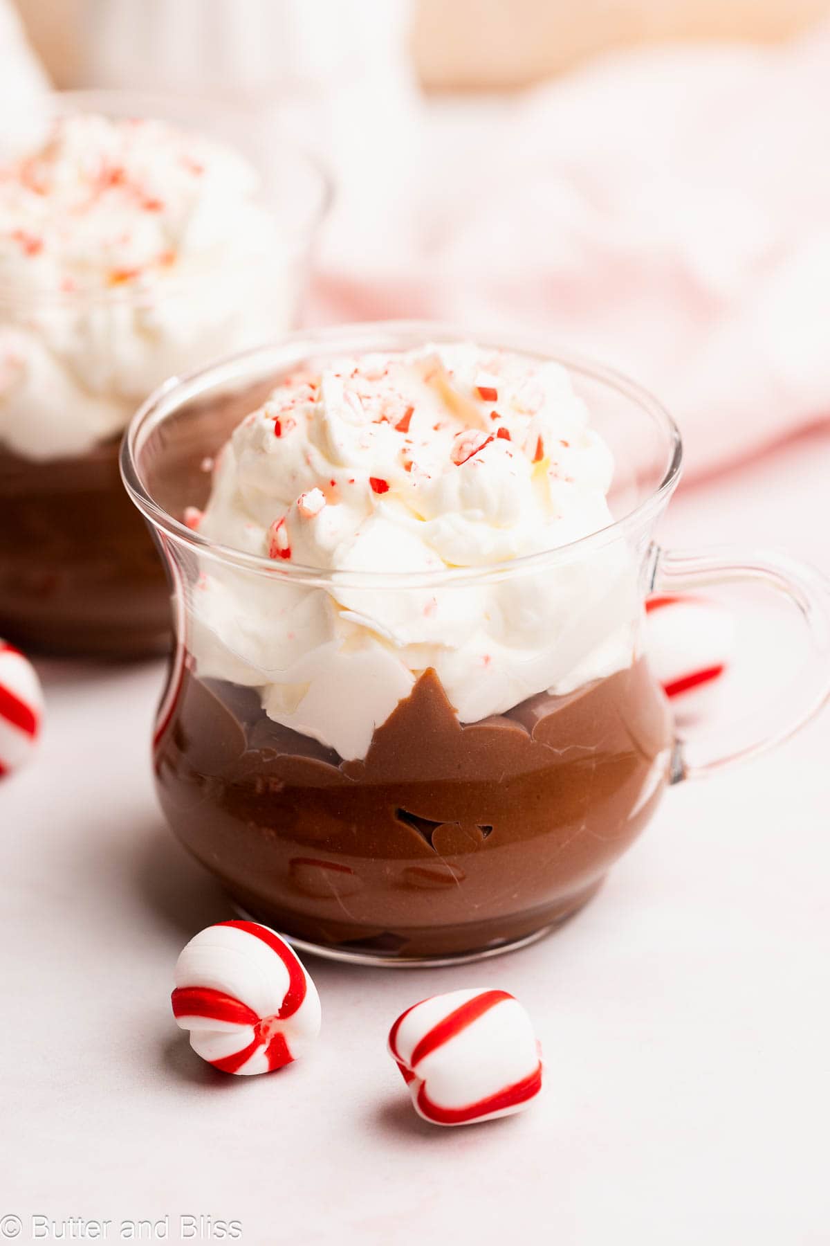Hot chocolate pudding with marshmallow whip in a pretty clear mug.