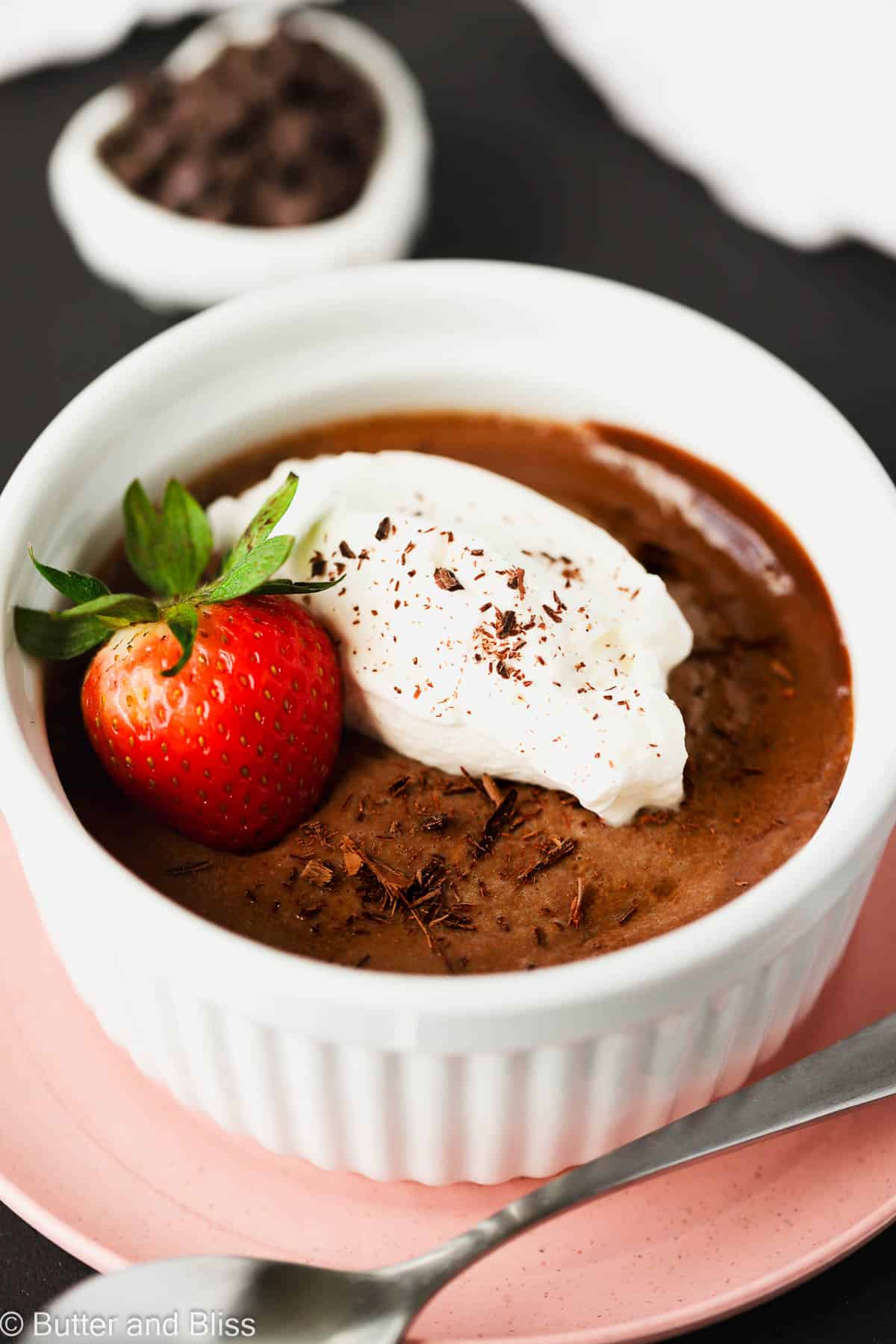Creamy chocolate dessert for Valentine's Day in a white dish set on a pink plate.