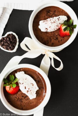 Chocolate pots de creme for two in individual ramekins and topped with whipped cream.