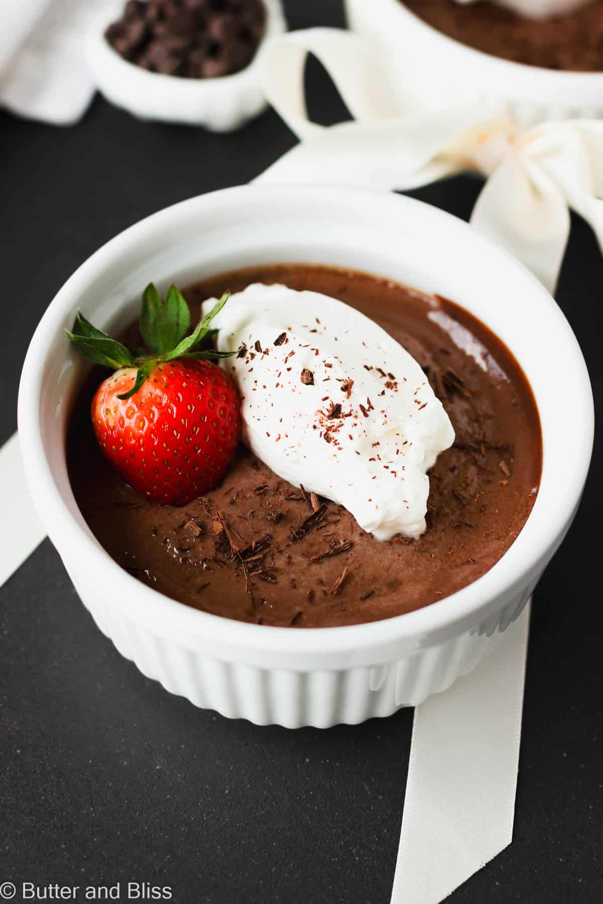 Velvety Valentine's Day chocolate dessert in pretty white dish with whipped cream.