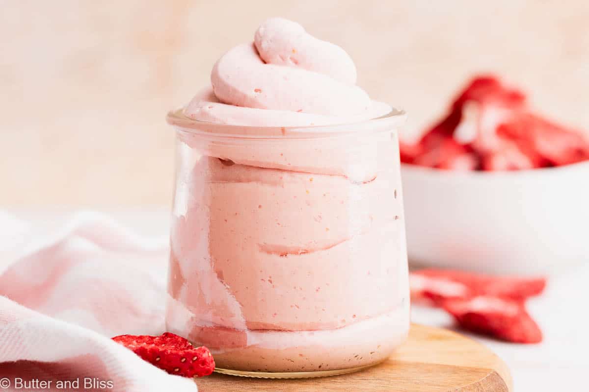 Close up of strawberry whipped cream in a pretty glass jar.
