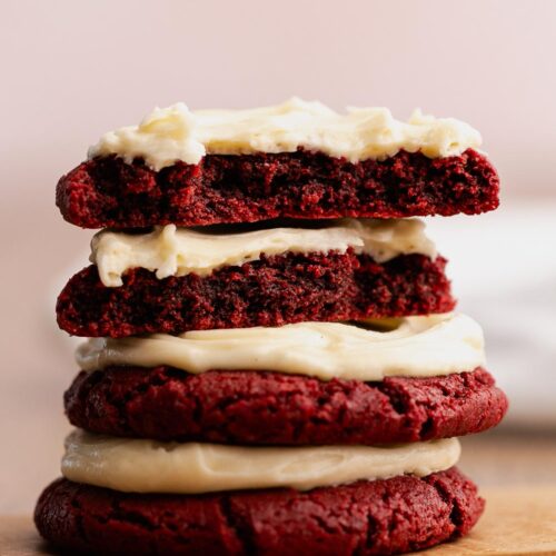 Small stack of frosted red velvet cookies for two on a table.