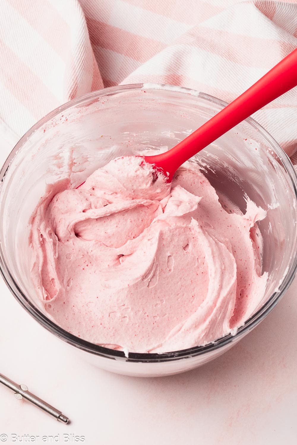 A bowl of fluffy whipped strawberry cream.