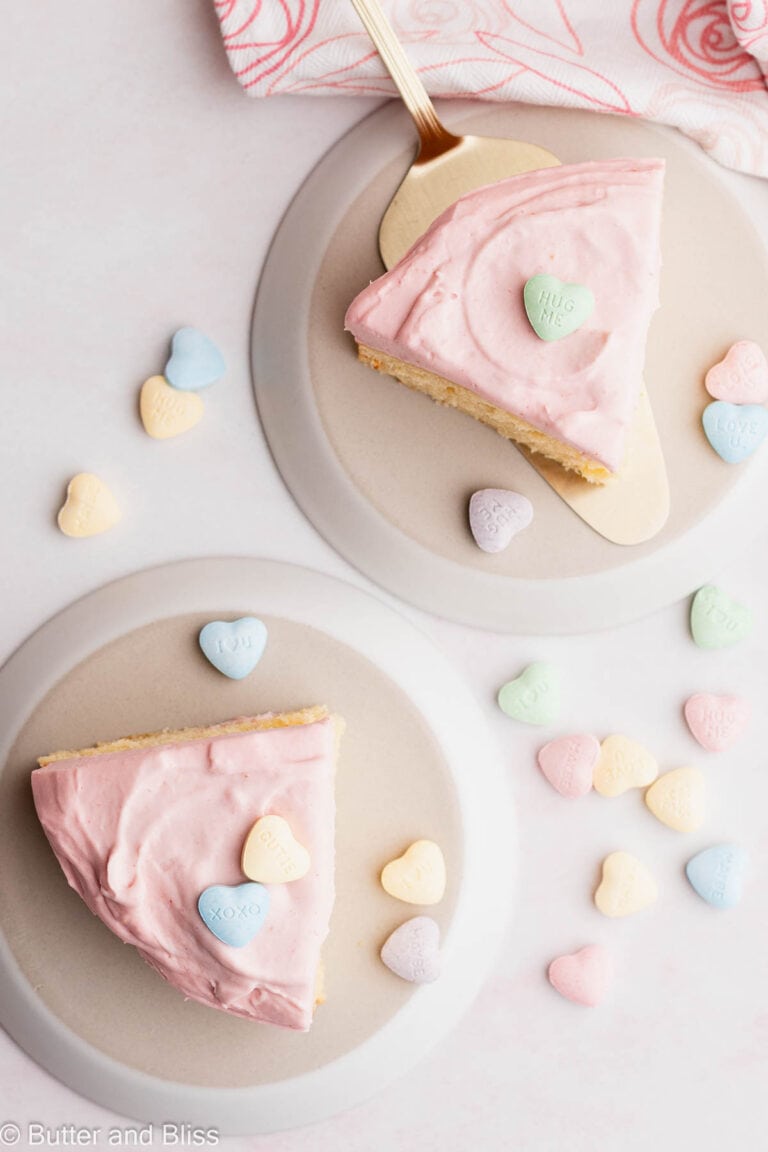 Slices of vanilla mini cake on white plates decorated with Valentine's day candy.