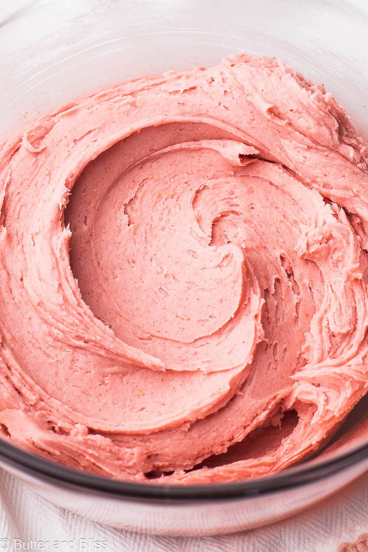 Bowl of creamy butter free strawberry frosting.