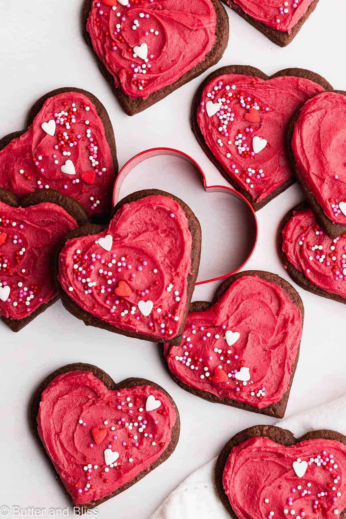 Frosted chocolate cream cheese cookies on a table decorated for Valentine's Day.