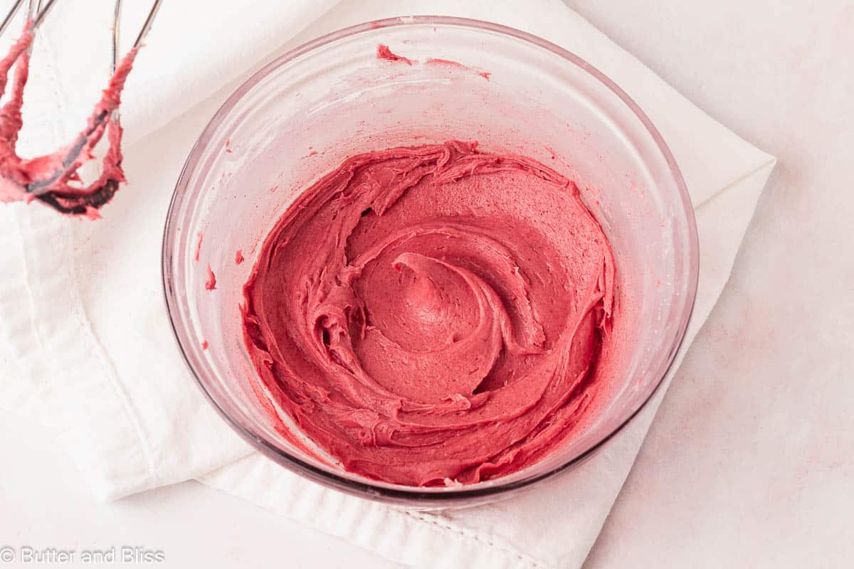 Vibrant raspberry cream cheese frosting in a bowl.