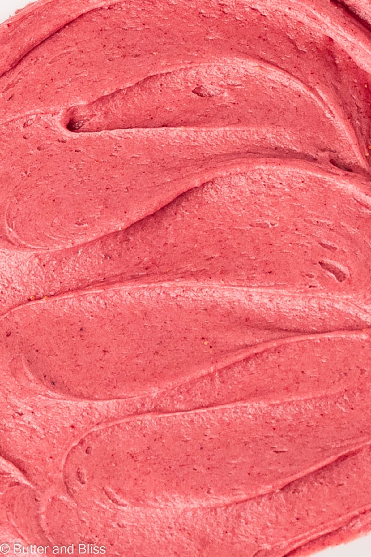 Vibrant and smooth close up of raspberry cookie frosting.